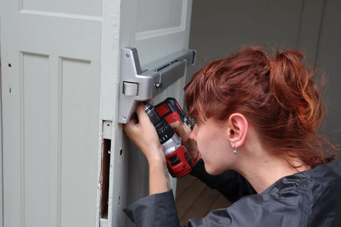 Worker using a drill during a door installation.