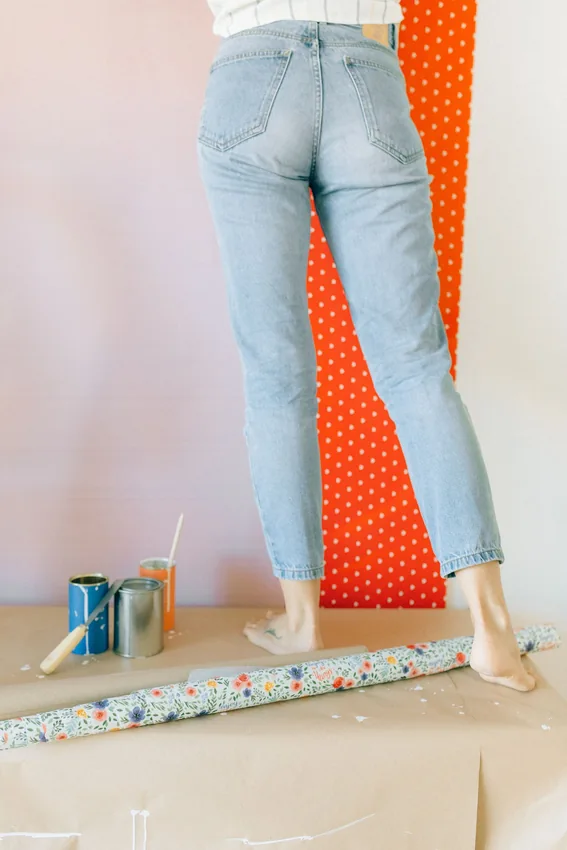 Person applying wallpaper as an interior wall finish.